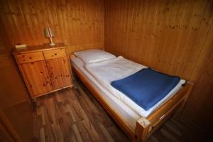 レンブルッフにあるFerienhaus 2 Köhr-Eickhoffのナイトスタンド付きの木製の部屋の小さなベッド1台