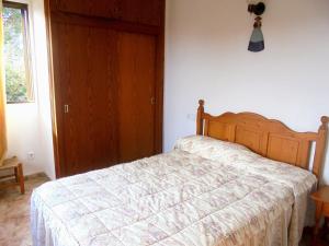 a bedroom with a bed with a wooden headboard at Apartamento Jordi in Cala Figuera