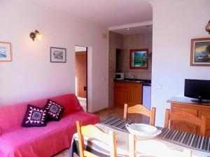 a living room with a red couch and a table at Apartamento Jordi in Cala Figuera