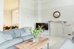 a living room with a blue couch and a table at Ramsay Gardens - Grand 4-Bedroom Apartment Next To Castle in Edinburgh