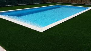 a swimming pool on a grassy area with a swimming pool at Chambre d'Hôtes Le Moulin d'Encor in Seysses-Savès