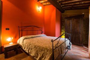 キャンニにあるRustico in Pietraのオレンジ色の壁のベッドルーム(ベッド1台、テーブル付)