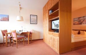 ein Hotelzimmer mit einem Esstisch und einem TV in der Unterkunft Inselresidenz Strandburg - Ferienwohnung 303 (Ref. 50971) in Juist