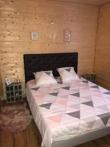 a bedroom with a large bed in a wooden wall at Arizona Dream in Lanouaille