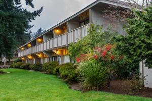 an exterior view of a building with plants and flowers at Red Lion Hotel Bellevue in Bellevue