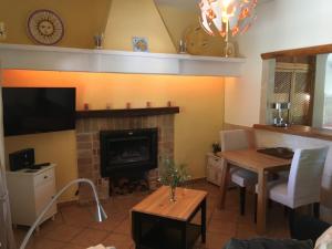 リュックマヨールにあるCasa Calendulaのリビングルーム(暖炉、テーブル、テレビ付)