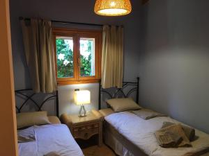 リュックマヨールにあるCasa Calendulaの窓とランプ付きの部屋のベッド2台