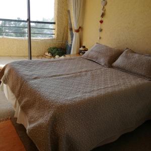 a bedroom with a large bed with a window at Depto. Vistamar Oriente in Papudo