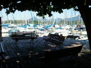 two benches on a dock with boats in a marina at Apartamento Piccola Marina in Angra dos Reis