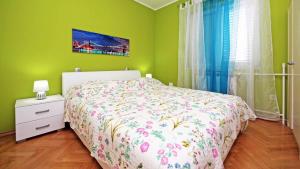 ein Schlafzimmer mit einem Bett und einer grünen Wand in der Unterkunft Apartment Ljubica in Vodice
