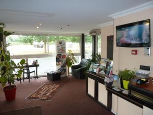 a living room with a flat screen tv on a wall at Quick Palace Poitiers in Chasseneuil-du-Poitou