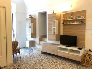 a living room with a flat screen tv on a cabinet at Old Town House Polignano a Mare in Polignano a Mare