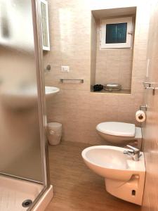 a bathroom with a sink and a toilet and a shower at Old Town House Polignano a Mare in Polignano a Mare