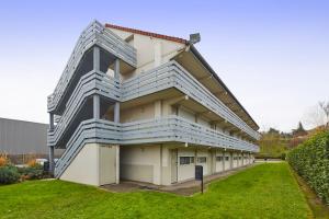 un edificio con balcones azules y blancos. en Campanile Epône, en Épône