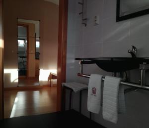 uma casa de banho com lavatório e toalhas brancas em Penthouse - Low Cost em Vouzela