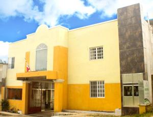 un edificio amarillo y blanco con bandera en Rosvel Hotel, en Palenque