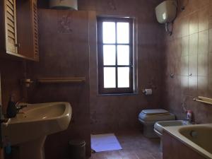 a bathroom with a sink and a toilet and a window at Mille Soli Bed and Breakfast in Buggerru +14 photos