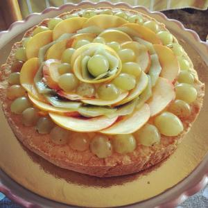 a cake with fruit on top of it on a plate at Mille Soli Bed and Breakfast in Buggerru