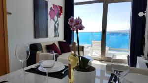 una mesa con vasos y un jarrón con flores. en Luxury apartment on the 40th floor with amazing views, en Benidorm