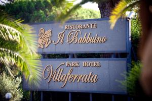 a sign on the side of a building with palm trees at Park Hotel Villaferrata in Grottaferrata