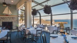 a restaurant with tables and chairs with a view of the ocean at Atlantic Oceanside Hotel & Conference Center in Bar Harbor