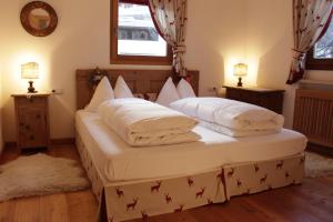 two twin beds in a room with two lamps at Villa Moroder in Ortisei