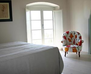 sypialnia z łóżkiem, krzesłem i oknem w obiekcie Casavaliversi Appartamenti w mieście Sesto Fiorentino