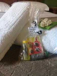 a plastic bag with scissors and other items on a bed at Pousada Nascer do Sol in Tiradentes