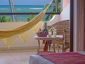 um quarto com rede de descanso, mesa e vista para o oceano em Porto da Lua Boutique Hotel na Praia do Forte