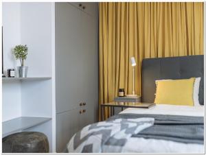a bedroom with a bed and a yellow curtain at Old Town Studio - Panoramic City View in Bucharest