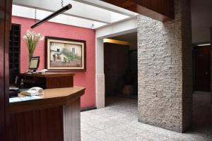 Hotel Ram Val في زامورا دي هيدالغو: غرفة بجدار وردي مع منضدة وممر