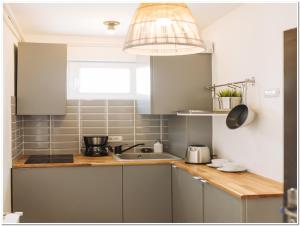 a kitchen with gray cabinets and a sink at Old Town Studio - Panoramic City View in Bucharest