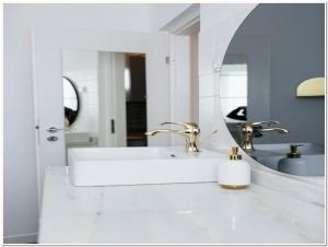 a white bathroom with a sink and a mirror at Old Town Studio - Panoramic City View in Bucharest +47 photos