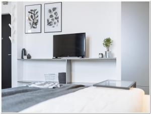 a bedroom with a bed and a tv on a wall at Old Town Studio - Panoramic City View in Bucharest