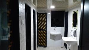 La salle de bains est pourvue d'un lavabo, de toilettes et d'un miroir. dans l'établissement One Step Hostel, à Mumbai
