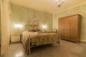 a bedroom with a bed and a wooden cabinet at Hotel Corona Grossa in Balangero