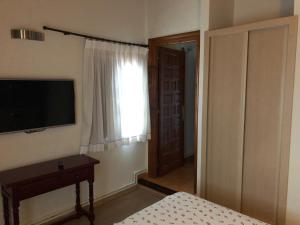 a bedroom with a television on the wall and a window at Hotel Costa San Juan De La Canal in Soto de la Marina