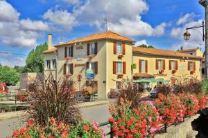 a yellow building with flowers in front of it at Logis Le Cheval Blanc et Le Clovis in Vouillé