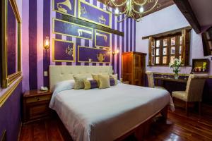 a bedroom with a large bed with purple walls at Grand Guadalupe by Inmense in San Cristóbal de Las Casas