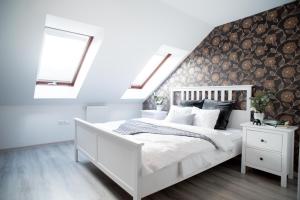 ブダペストにあるGrand Trees Apartmentの白いベッド1台(木製ヘッドボード付)が備わるベッドルーム1室が備わります。
