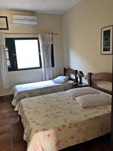 2 camas en un dormitorio con ventana en Hotel Residencial Itaicy en Iguape