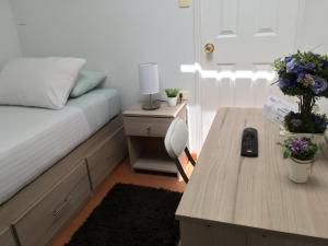 1 dormitorio con cama y mesa con espejo en Fragga Hospedaje Boutique, en Antofagasta