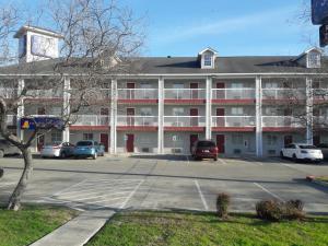 a large building with cars parked in a parking lot at InTown Suites Extended Stay San Antonio TX - Nacogdoches Road in San Antonio