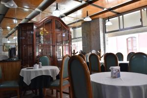 uma sala de jantar com duas mesas e cadeiras e um quarto com janelas em Hotel Ram Val em Zamora de Hidalgo