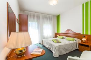 1 dormitorio con 1 cama y 1 mesa con lámpara en Hotel Tegorzo, en Fener