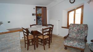 a dining room with a table and a chair at B&B La Casa Rosa in Balze