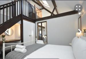 a bedroom with a large bed with a staircase at The Tollgate Inn in Bradford on Avon