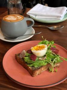 a piece of toast with an egg and a cup of coffee at Cachet Boutique Hotel NYC in New York