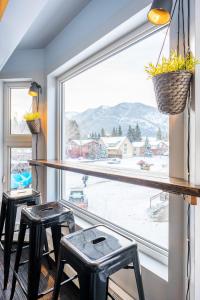 a room with two stools and a large window at Samesun Banff Hostel in Banff