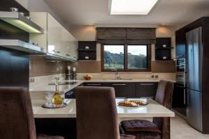a kitchen with a table and a refrigerator at Callista Luxury Residences in Ierapetra